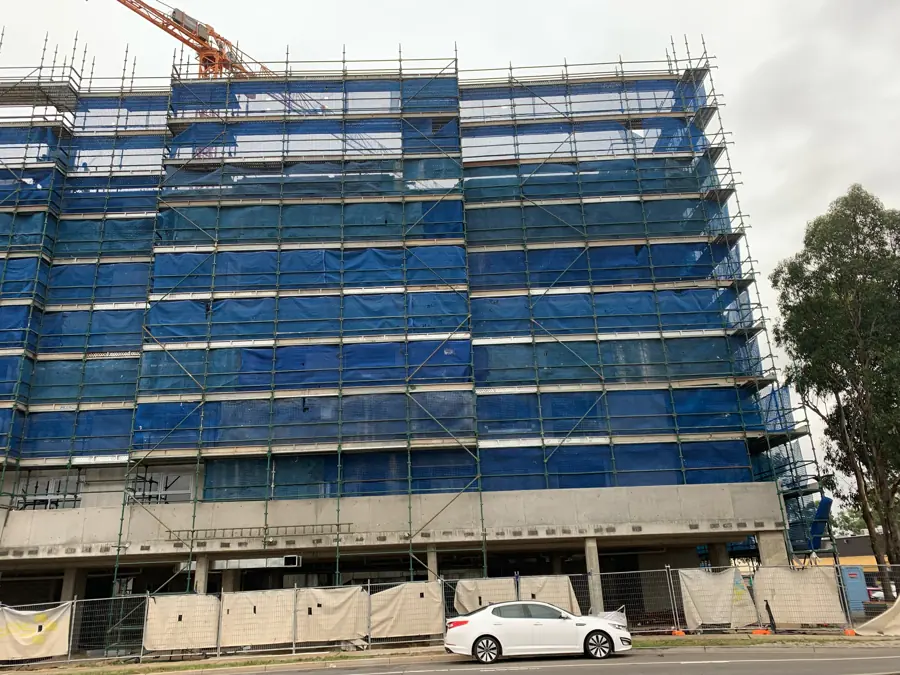 Blue scaffold and protection mesh on a multi-storey construction project